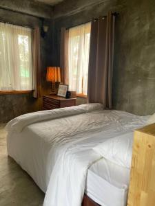 a bedroom with a large bed and a desk and window at Quiet Page CNX in Ban Phae Buak Ha