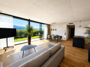 a living room with a couch and a large window at View - AgriSuites in Caldaro