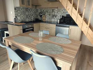 a kitchen with a wooden table and blue chairs at Ker Louwen chambre d' hôte in Corseul