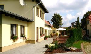 a courtyard of a building with benches and an umbrella at Spreewaldapartments-Kossatz in Lübben