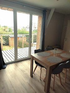 a dining room with a table and a sliding glass door at Ker Louwen chambre d' hôte in Corseul +1 photo