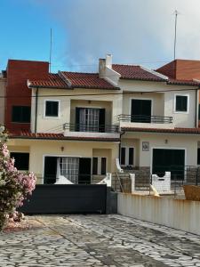 a large white house with red roof at Rolo House in Nazaré