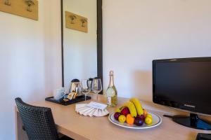 a desk with a plate of fruit and a television at Borgo Del Principe in Zambrone