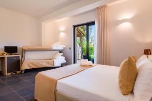 a bedroom with two beds and a balcony at Borgo Del Principe in Zambrone