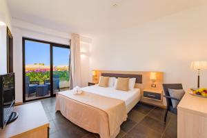 a hotel room with a bed and a television at Borgo Del Principe in Zambrone