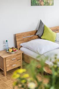 a bed with a bowl of fruit on a table at Der Teichhof in Grandenborn