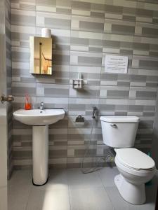 ein Badezimmer mit Toilette und Waschbecken in der Unterkunft Phines Place in Panglao