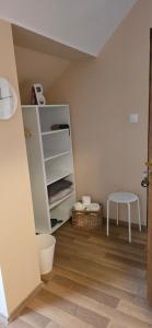 a room with a white shelf and a table at Határ Motel in Somoskőújfalu