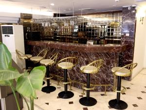 a bar with gold stools in front of a counter at Akyuz Hotel in Ankara