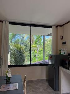eine Küche mit Fenster und Tisch und Kühlschrank in der Unterkunft Phines Place in Panglao