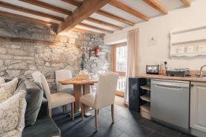 a kitchen and dining room with a table and chairs at Critchlow Cottage in Buxton