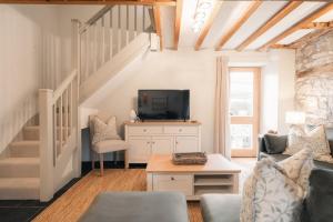 a living room with a couch and a tv at Critchlow Cottage in Buxton