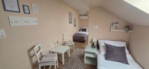 a small bedroom with a bed and a table and chairs at Határ Motel in Somoskőújfalu