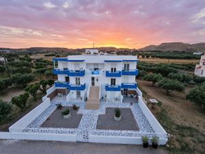 an aerial view of a white house with a sunset in the background at Pittas Studios in Kardamaina