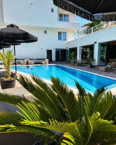 a swimming pool with an umbrella and some plants at JI HOTEL in Sozopol