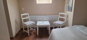 a room with a table and two chairs and a bed at Határ Motel in Somoskőújfalu