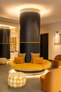 a living room with a yellow couch and chairs at Aparthotel Colombo Roma in Rome +62 photos