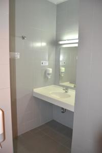 a bathroom with a sink and a mirror at HI Porto - Pousada de Juventude in Porto