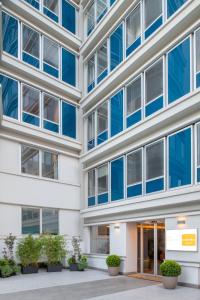 an office building with blue windows and potted plants at Aparthotel Colombo Roma in Rome