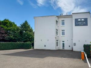 a white building with a sign on the side of it at Limok Rooms Nordenham in Nordenham