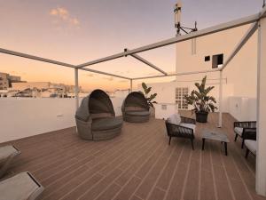 a rooftop deck with chairs and a table on a building at Pebbles Resort in St. Paul's Bay