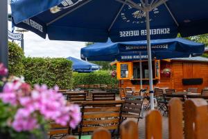 a group of tables and chairs under an umbrella at DLRG Tagungszentrum Hotel Delphin in Bad Nenndorf