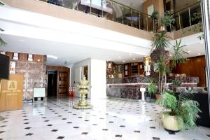 a lobby of a hotel with plants and a fountain at Akyuz Hotel in Ankara
