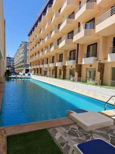 a swimming pool in front of a building at Lavanda Beach Resort in Abū Rudays
