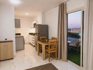 a kitchen with a table and a refrigerator at Lavanda Beach Resort in Abū Rudays