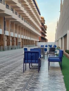 a row of blue benches sitting outside of a building at Lavanda Beach Resort in Abū Rudays