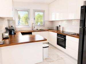 a kitchen with white cabinets and a wooden counter top at Villa Celestia in Neo Chorio +4 photos