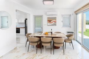a kitchen and dining room with a wooden table and chairs at Villa Celestia in Neo Chorio