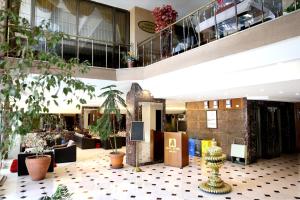 a lobby of a building with plants on the floor at Akyuz Hotel in Ankara