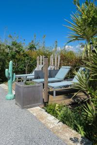 a patio with a chair and a cactus at Entre Mer et Vignes in Nissan-lez-Enserune