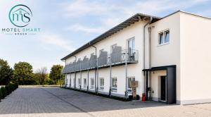 a large white building with a parking lot at Motel Smart in Bogen