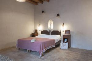 a bedroom with a bed and a table with a bag at Villa Salinara in Marsala