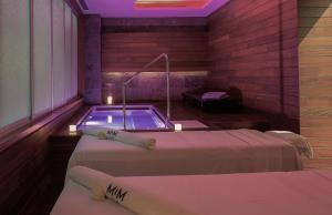 a room with two beds and a bath tub at MiM Sitges member of Meliá Collection in Sitges