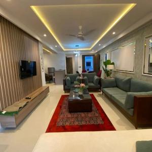 a living room with a couch and a table at Park Ridge Hotel Serviced Apartments - One Bedroom Apartment in Murree