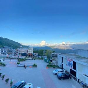 a parking lot with cars parked in front of a building at Park Ridge Hotel Serviced Apartments - One Bedroom Apartment in Murree