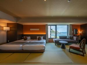a large bedroom with a large bed and a couch at Atami Hotel Nagisakan in Atami +50 photos