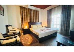 a bedroom with a bed and a chair at Three-Bedroom Holiday Home in Abbottabad