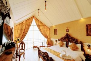 a bedroom with a bed with a swan on it at Kali Tibba Resort Chail in Chail
