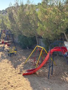 a playground with a slide in the sand at Cozy farm in Jerash