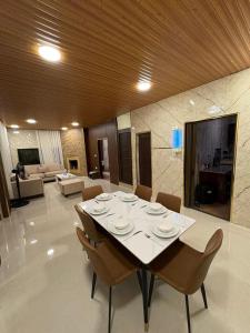 a dining room with a table and chairs and a living room at Cozy farm in Jerash