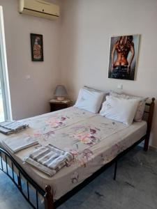 a bedroom with a bed with a blanket on it at Nikoletta in Ancient Epidauros
