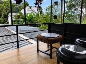 a balcony with a table and two stools at Birdwing Cottage, Munnar in Munnar
