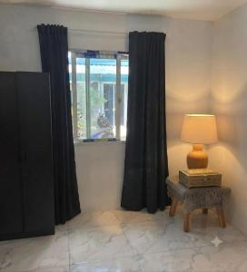 a room with black curtains and a table with a lamp at SET Inn-2 in Kata Beach +5 photos