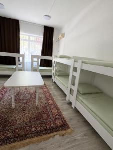 a room with two bunk beds and a table at Global Hostel 3 in Almaty