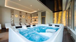 a bath tub with blue water in a room at Boulevard Drobnera SPA&Wellness - Restaurant PONTI - Widok na Odre in Wrocław