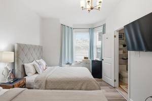 a white bedroom with two beds and a window at Serenity Inn in Niagara Falls